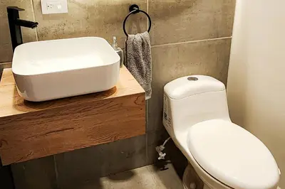 a bathroom with a white toilet and a sink at Las Lomas Luxury House2 in Medellín