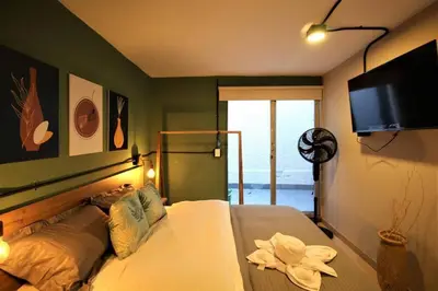 a bedroom with a bed and a flat screen tv at Apartamento privado con patio interno ONE103 By Roots Rentals in Medellín