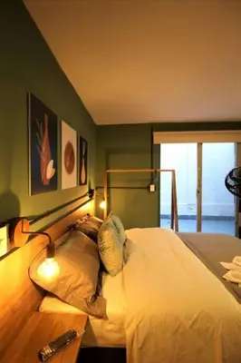 a bedroom with a bed and a table with lights at Apartamento privado con patio interno ONE103 By Roots Rentals in Medellín
