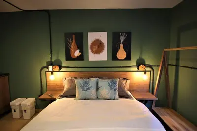 a bedroom with a bed and some pictures on the wall at Apartamento privado con patio interno ONE103 By Roots Rentals in Medellín