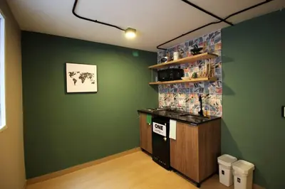 a room with a green wall with a counter and a shelf at Apartamento cerca Universidad Medellín ONE104 By Roots Rentals in Medellín