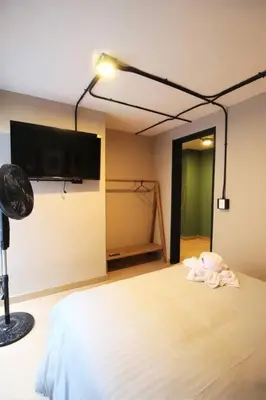 a bedroom with a bed with a tv on the wall at Apartamento cerca Universidad Medellín ONE104 By Roots Rentals in Medellín