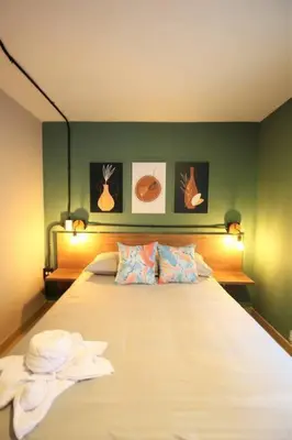 a bedroom with a bed with a green wall at Apartamento cerca Universidad Medellín ONE104 By Roots Rentals in Medellín