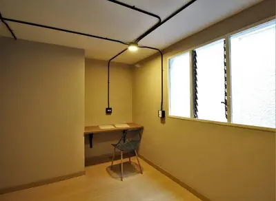 a room with a desk and a chair and a window at Apartamento cerca Universidad Medellín ONE104 By Roots Rentals in Medellín
