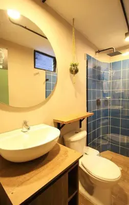a bathroom with a sink and a toilet and a mirror at Apartamento cerca Universidad Medellín ONE104 By Roots Rentals in Medellín