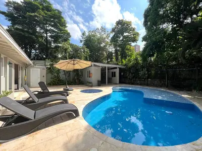 a swimming pool with chairs and an umbrella at Luxury Villa In Aguacatala2 in Medellín