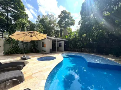 a large swimming pool with an umbrella and chairs at Luxury Villa In Aguacatala2 in Medellín