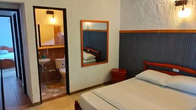 a bedroom with a bed and a sink and a mirror at Finca Turística Peñoles - Cerca de Charcos y Cascadas - Finca Rústica en San Carlos, Antioquia in San Carlos