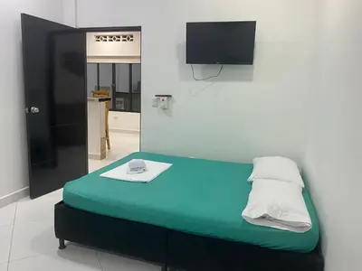 a bed in a room with a tv on the wall at APARTAMENTO DORADAL in Doradal
