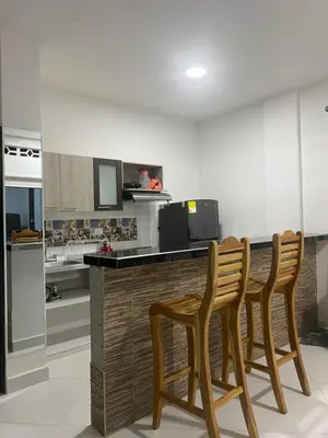 a kitchen with three wooden chairs at a counter at APARTAMENTO DORADAL in Doradal
