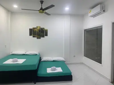 a room with two beds and a ceiling fan at APARTAMENTO DORADAL in Doradal
