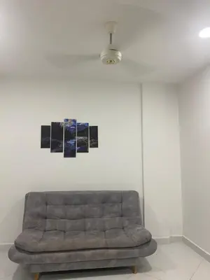 a couch in a living room with three pictures on the wall at APARTAMENTO DORADAL in Doradal