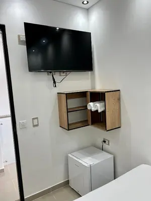 a bathroom with a flat screen tv on a wall at HOTEL TORRE DELUXE ¨SANTORINI¨ in Doradal