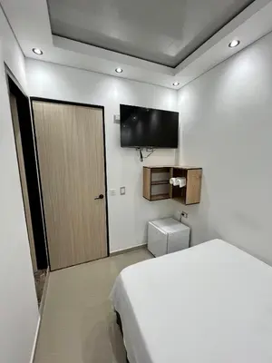 a bedroom with a bed and a flat screen tv at HOTEL TORRE DELUXE ¨SANTORINI¨ in Doradal