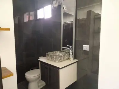 a bathroom with a white toilet and a sink at Gorgeous Penthouse Apartment in Medellin in Medellín