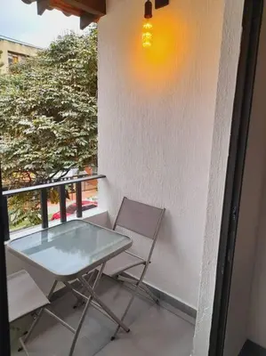a glass table and two chairs on a balcony at Gorgeous Penthouse Apartment in Medellin in Medellín