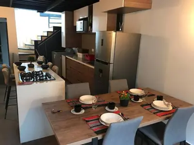 a kitchen with a wooden table with chairs and a stove at Gorgeous Penthouse Apartment in Medellin in Medellín