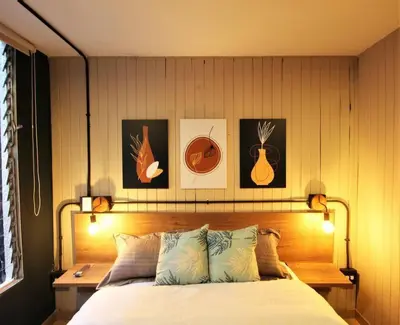 a bedroom with a bed and some pictures on the wall at Apartamento que permite mascota en Medellín ONE105 By Roots Rentals in Medellín