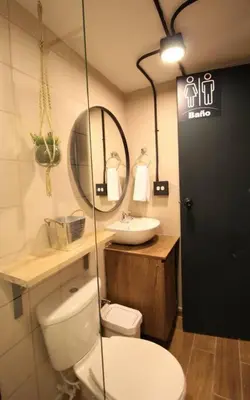 a bathroom with a toilet and a sink and a mirror at Apartamento con cocina y baño privado - ONE106 By Roots Rentals in Medellín