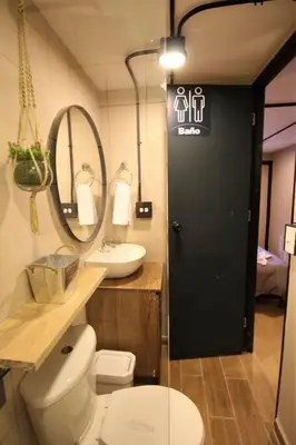 a bathroom with a toilet and a sink and a mirror at Apartamento con cocina y baño privado - ONE106 By Roots Rentals in Medellín