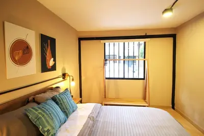 a bedroom with a bed and a large window at Apartamento con cocina y baño privado - ONE106 By Roots Rentals in Medellín