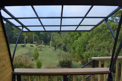 a screened in porch with a bench and a garden at Chalet Petit Verdot in Santa Elena