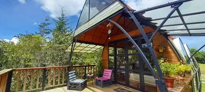 a house with a deck with two chairs on it at Chalet Petit Verdot in Santa Elena