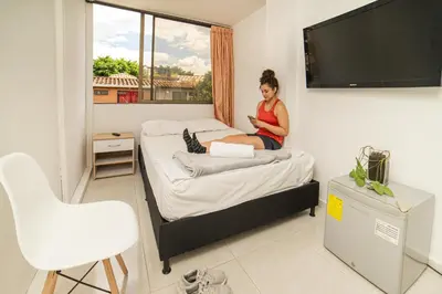 a woman sitting on a bed in a room at Alojamiento Acogedor con excelente ubicacion D in Medellín