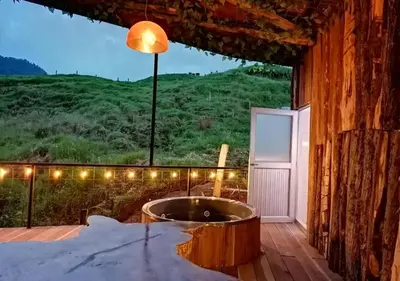 a tub on a deck with a view of a mountain at Hotel Cabañas y Chalets lujosos Mágica Luna Manizales in Villamaría