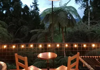 a table and chairs in front of a wall with lights at Hotel Cabañas y Chalets lujosos Mágica Luna Manizales in Villamaría
