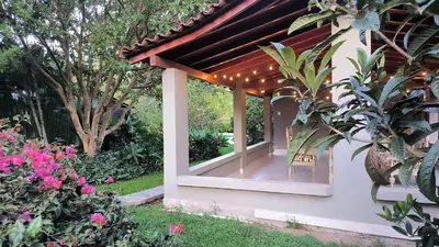 a pergola with lights on the side of a house at CASA HOTEL FIBA MAGUEZA in Guarne