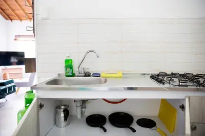 a kitchen with a sink and a stove at CASA HOTEL FIBA MAGUEZA in Guarne