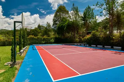 a tennis court with a basketball hoop at CASA HOTEL FIBA MAGUEZA in Guarne