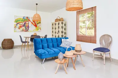 a living room with a blue couch and chairs at CASA HOTEL FIBA MAGUEZA in Guarne