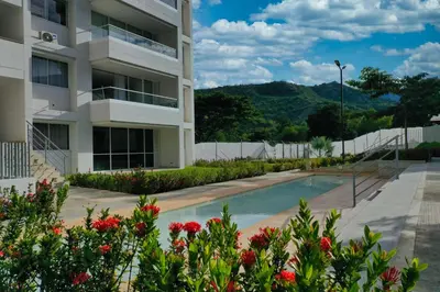 an apartment building with a swimming pool and flowers at Stunning, Brand-new Apartment in Santa Fe de Antioquia