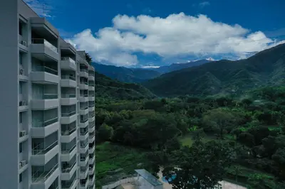a tall building with mountains in the background at Stunning, Brand-new Apartment in Santa Fe de Antioquia