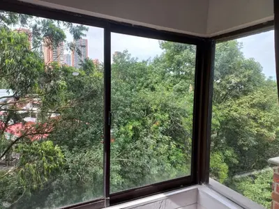 a window in a room with a view of trees at Poblado la 10 in Medellín