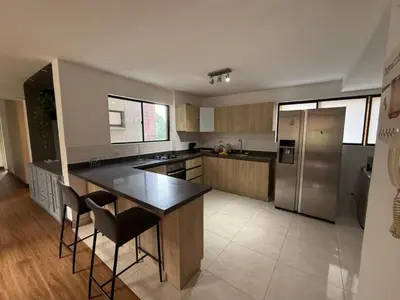 a large kitchen with a stainless steel refrigerator and counters at Poblado la 10 in Medellín