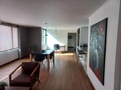 a living room with a dining room table and chairs at Poblado la 10 in Medellín