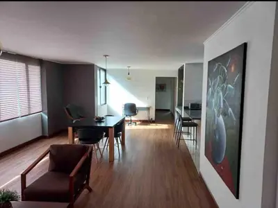 a living room with a dining room table and chairs at Poblado la 10 in Medellín