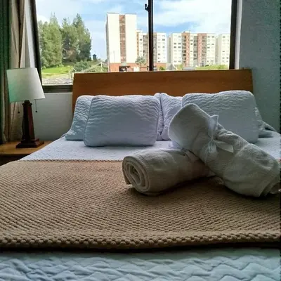 a bed with towels on it with a window at Bonito apartamento con excelente ubicación in Manizales