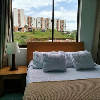 a bedroom with a bed with a large window at Bonito apartamento con excelente ubicación in Manizales