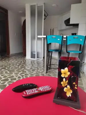 a table with two remote controls on a red rug at Bonito apartamento con excelente ubicación in Manizales