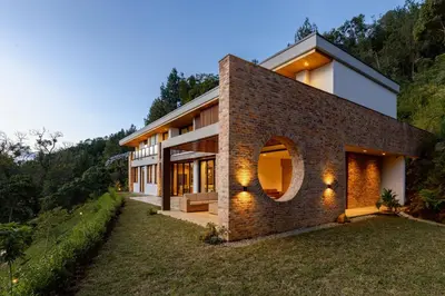 a brick house with a round window on a hill at Hilltop Enchanting Villa with Stunning Views & Jacuzzi in Medellín