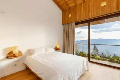 a bedroom with a bed and a large window at Hilltop Enchanting Villa with Stunning Views & Jacuzzi in Medellín