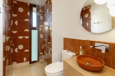 a bathroom with a sink and a toilet and a mirror at Hilltop Enchanting Villa with Stunning Views & Jacuzzi in Medellín