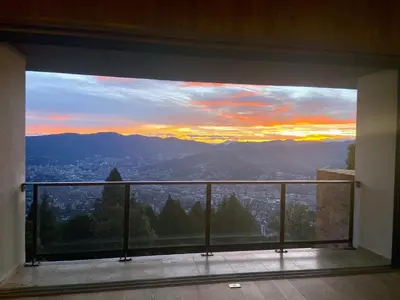 a view of a sunset from a balcony at Hilltop Enchanting Villa with Stunning Views & Jacuzzi in Medellín