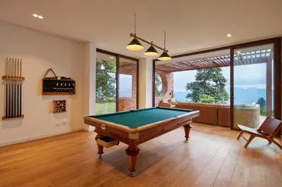 a pool table in a living room with a view at Hilltop Enchanting Villa with Stunning Views & Jacuzzi in Medellín
