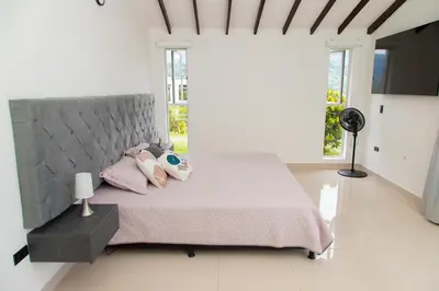 a bedroom with a large bed with pink sheets and pillows at Espectacular Villa en Copacabana in Copacabana