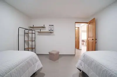 a white room with two beds and a ladder at Monte Hermoso - Apartamento campestre in Guatapé